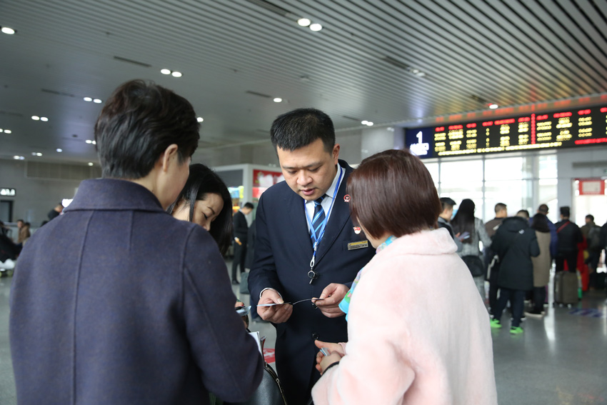 周扬在候车室内为旅客提供咨询服务。