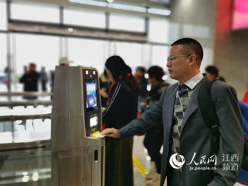 验证身份证和车票，对着摄像头“刷脸”，旅客只用了5秒钟进入站台。（廖国胜/摄）