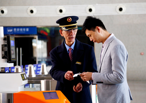 翁建忠為旅客查看電子客票信息，做好答疑解惑。黃旸/攝