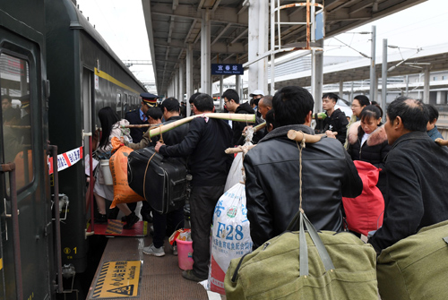 旅客在工作人員引導下有序乘車。