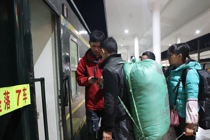 青年團員迎接旅客上車。金淑華 攝