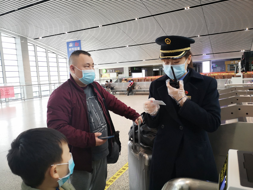 延平站共產黨員、客運值班員楊潔瓊為帶小孩出行的旅客答疑解惑。（趙海敏 攝）