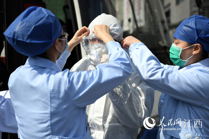 醫護人員協助司機穿戴防護服、眼罩、頭套等，做好相應的防護。（時雨/攝）