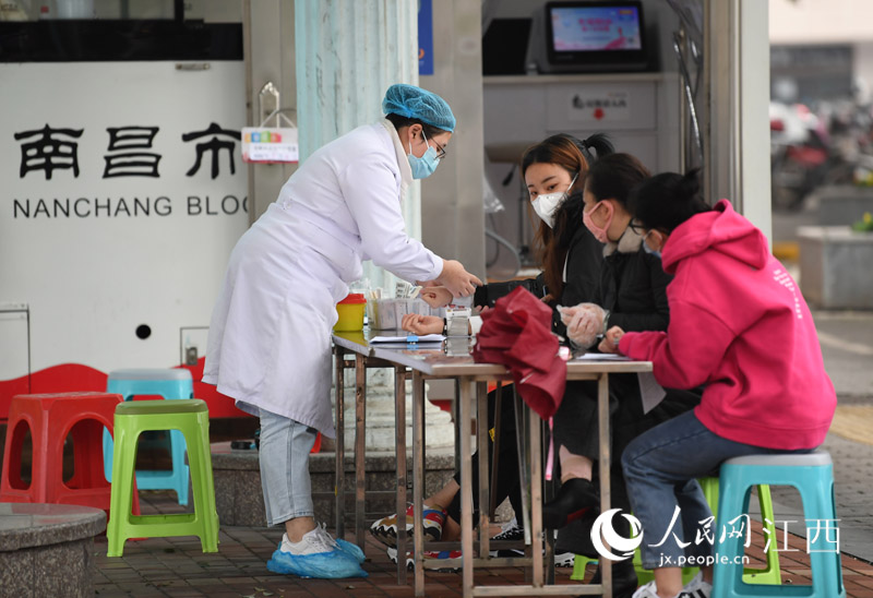 獻血車旁，工作人員正在為准備獻血的市民測量血壓。（時雨/攝）
