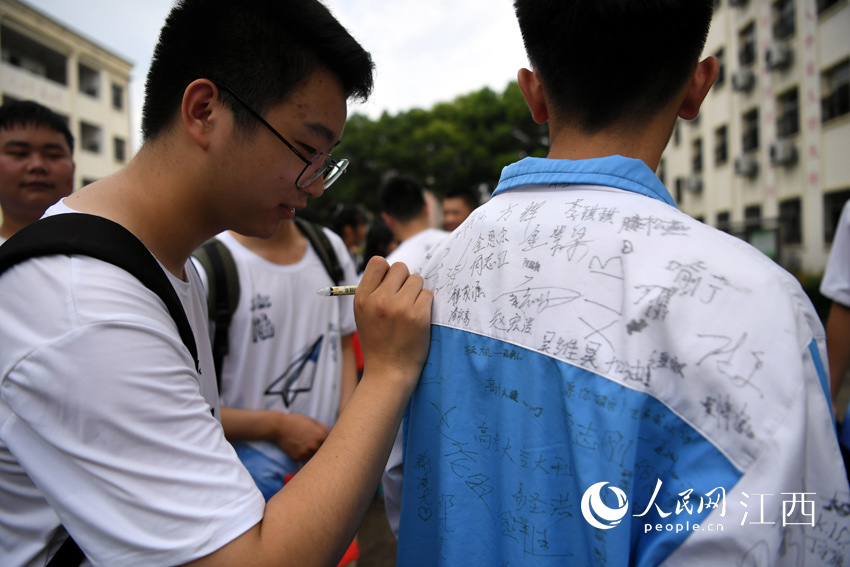 學生們在校服上互相簽名留念（人民網 時雨/攝）