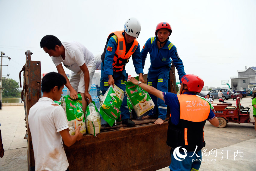 贵州省江西商会捐赠的救灾物资到达村委会后，队员们帮忙卸货分发。（人民网 时雨/摄）