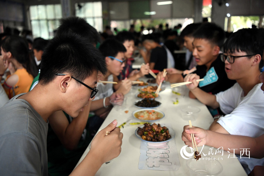 学生们在食堂内就餐，统一就餐保证了学生们的饮食安全。（人民网 时雨/摄）