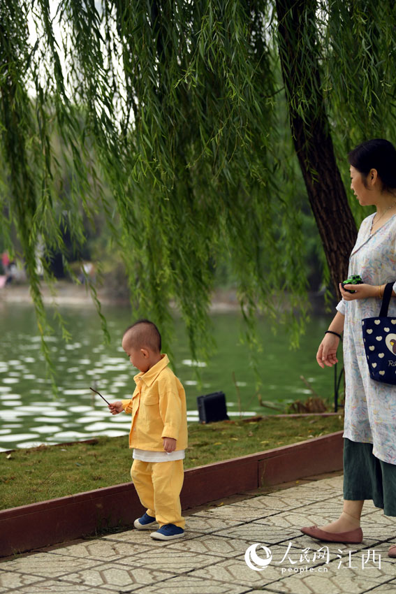 15日早晨的公園裡，一名幼童穿著厚實的衣物。（人民網 時雨/攝）