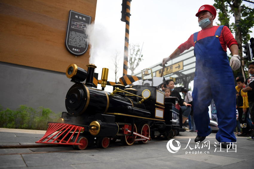 一列蒸汽小火車在街區內穿梭，接駁在街區內游玩的游客。（李慳/攝）
