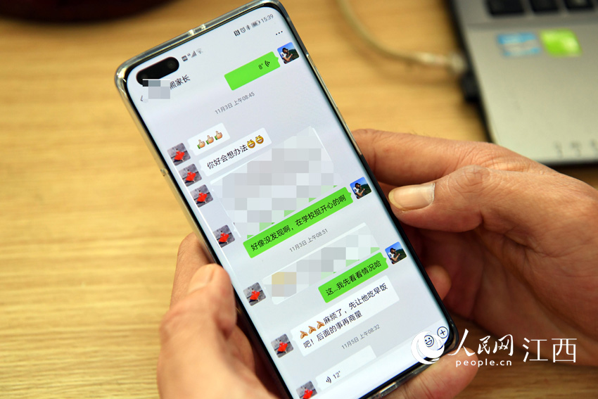 李向陽通過微信，與家長進行交流。（人民網 時雨/攝）