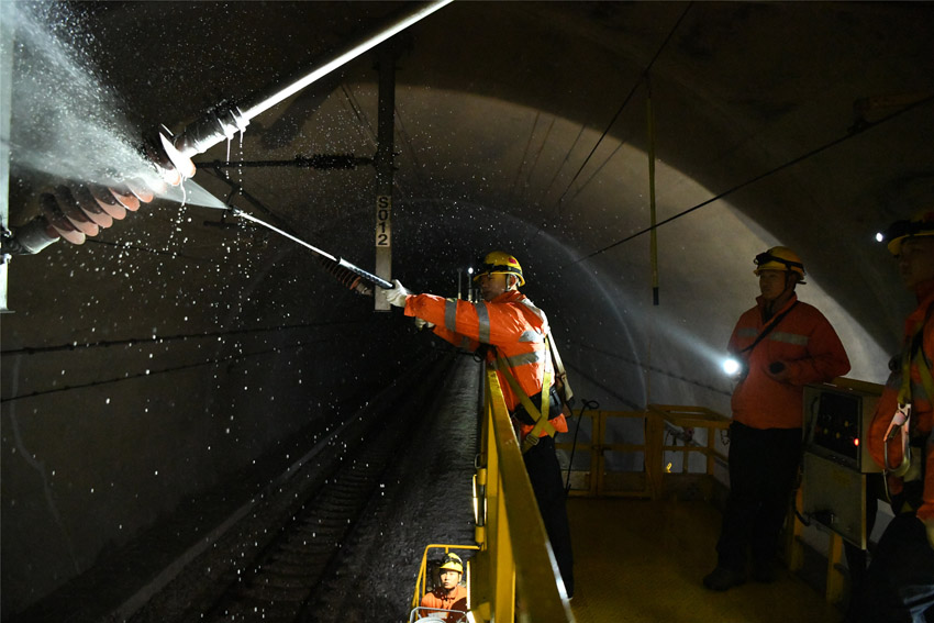 接觸網工在隧道內使用高壓水槍噴洗絕緣子。（郭鈺祺 攝）