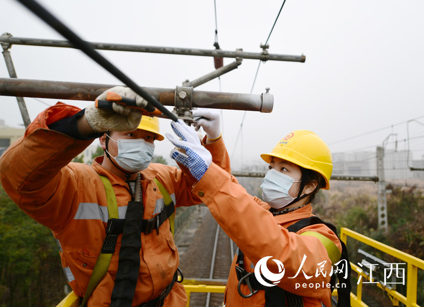 在武九鐵路瑞昌至白楊畈區段，女接觸網工左信子（右）與同事正在對接觸網設備進行檢修。（胡國林 攝）