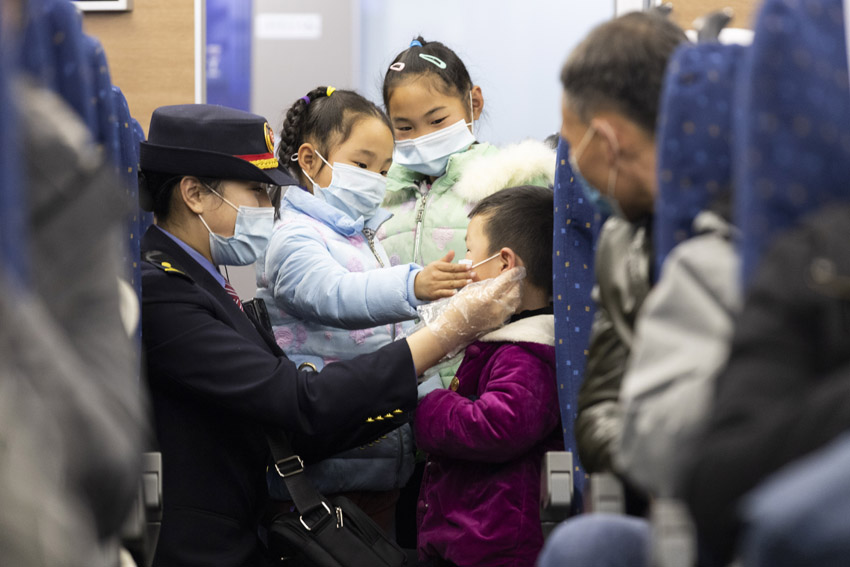 列車長正在耐心教著小旅客們如何正確佩戴口罩。李心柯 攝