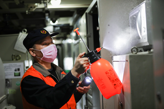 中國鐵路南昌局集團有限公司鷹潭機務段檢修人員對機車微波爐外側進行消毒。俞涂豐 攝