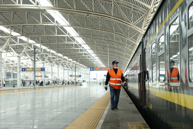 周建躍在站台上對列車進行巡視檢查。王超 攝