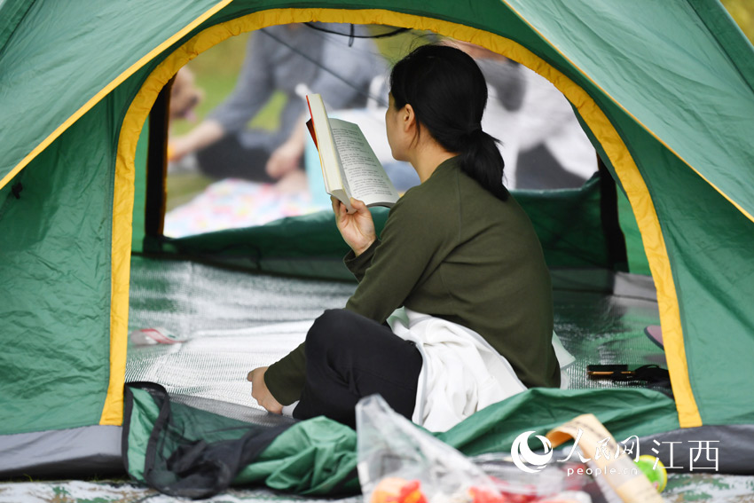 一位市民鬧中取靜，在帳篷內認真看書。（人民網 時雨攝）
