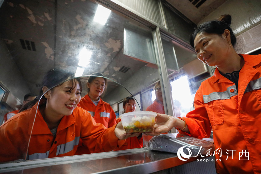 女子養護組的女職工們在食堂的餐車上排隊打飯就餐。（汪翰 攝）