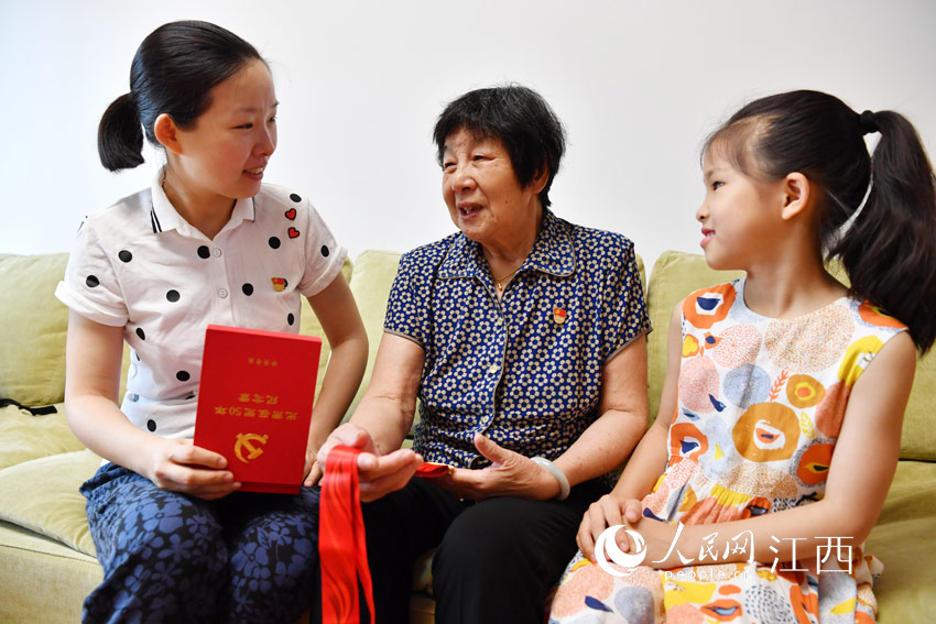 陶桂蓮向孫女駱寒蕾（左）和重孫女王欣禾（右）講述退休前的工作經歷。（人民網 時雨攝）