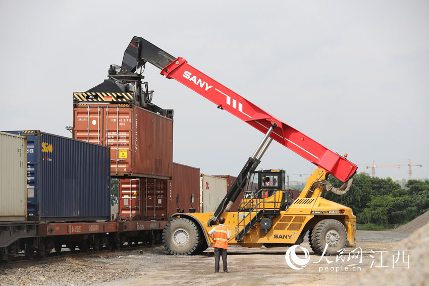 6月30日，在龙南站货场，铁海联运班列正在装载集装箱。（李心柯 摄）