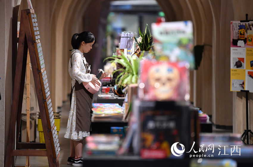 書店店員輕彈吉他，給看書的人們營造輕鬆愉悅的氛圍。（人民網 時雨攝）