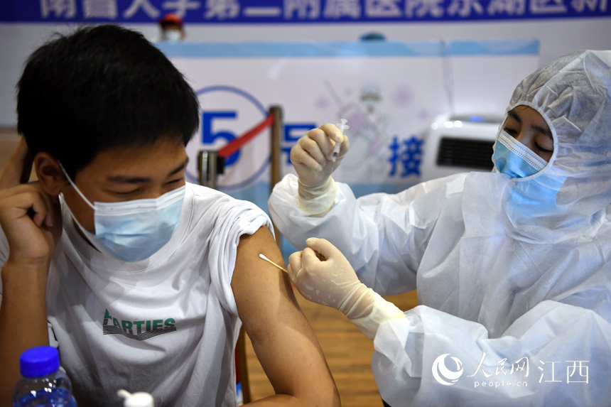 在江西省体育馆的新冠疫苗方舱接种点内,高中生正在接种新冠疫苗。(人民网 时雨摄)