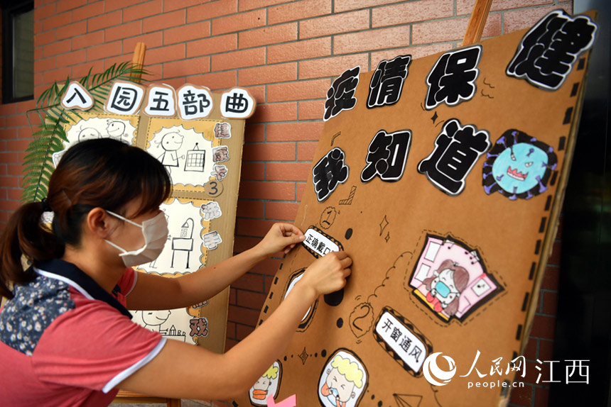 幼兒園員工正在制作防疫小提示。（人民網 時雨攝）