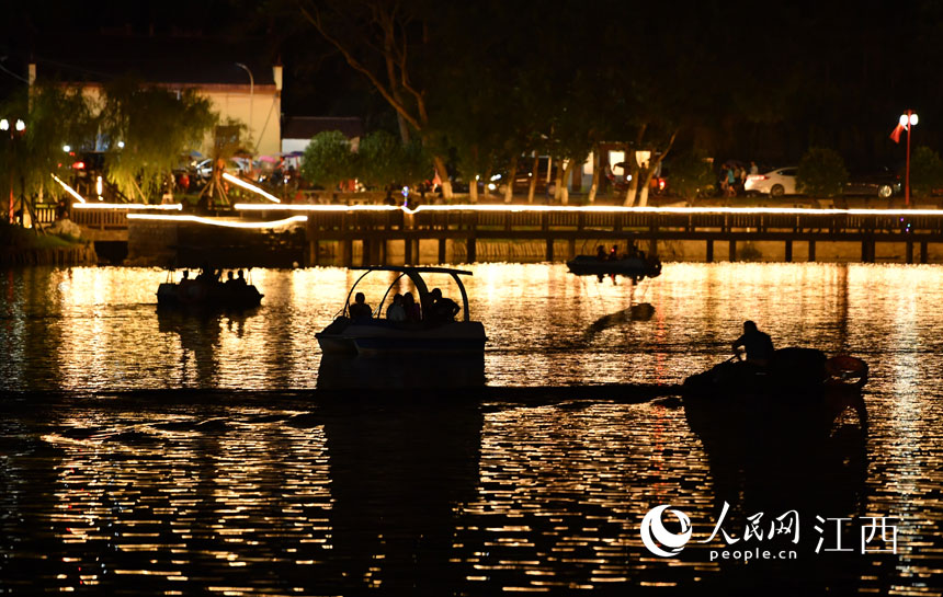 夜晚，游客们在“小西湖”里驾船畅游。人民网 时雨摄
