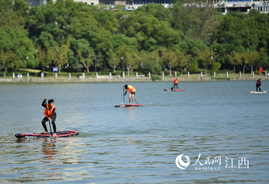 選手們在青山湖湖面上揮槳競技。 人民網 時雨攝