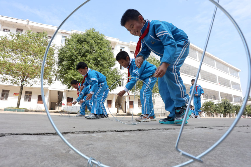 学生在玩滚铁环游戏。何江华 摄
