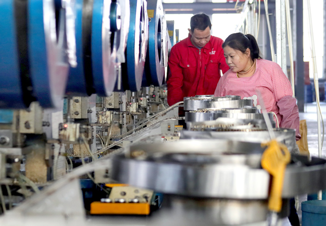 員工在華津電子科技有限公司電子產品自動生產線忙碌。何賤來攝