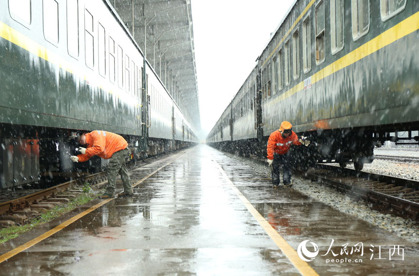 南昌車輛段九江運用車間檢車員正在檢修旅客列車。王超 攝