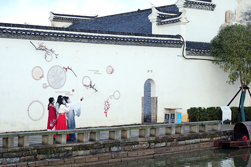 “漢服姐姐”在天寶古村藝術牆前游玩。何賤來 攝