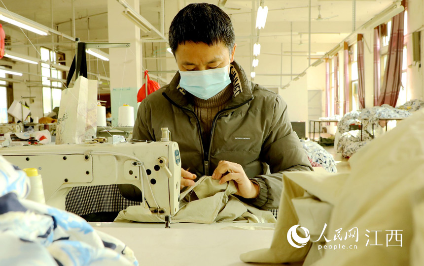 在永新縣禾川鎮一家服飾企業生產車間裡，工人正在趕制訂單。劉平華攝
