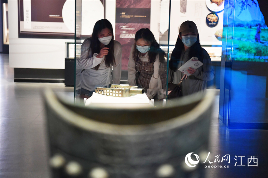 在江西省博物館內，參觀者正在仔細查看展櫃裡的文物。 人民網 時雨攝
