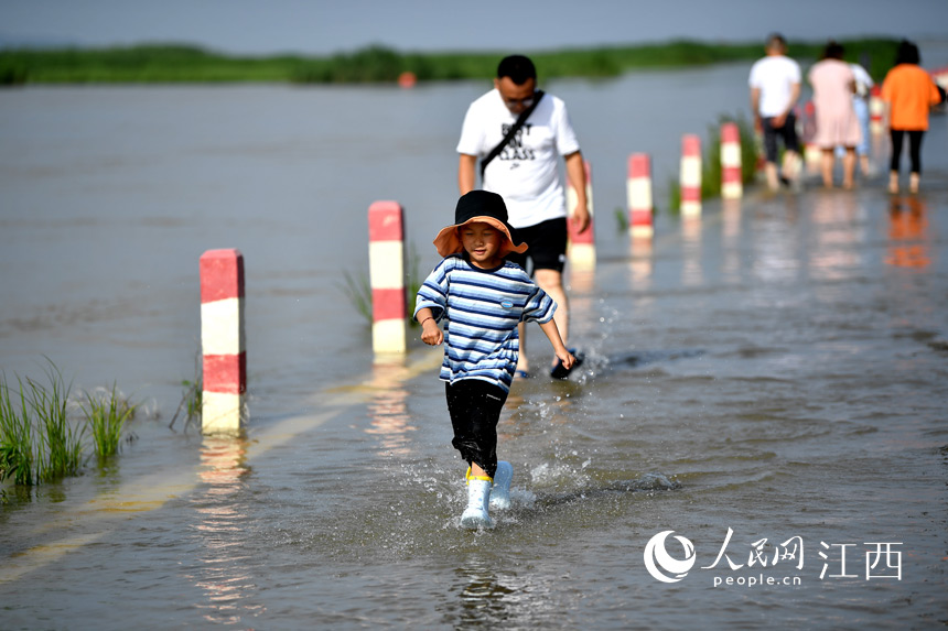 家長帶著小朋友在“水上公路”戲水。 人民網 時雨攝