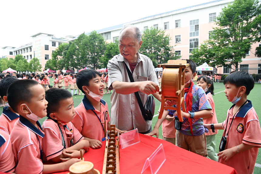 木匠师傅郭西灿带着自己制作的微缩农具来到学校让学生们体验。邓龙华摄