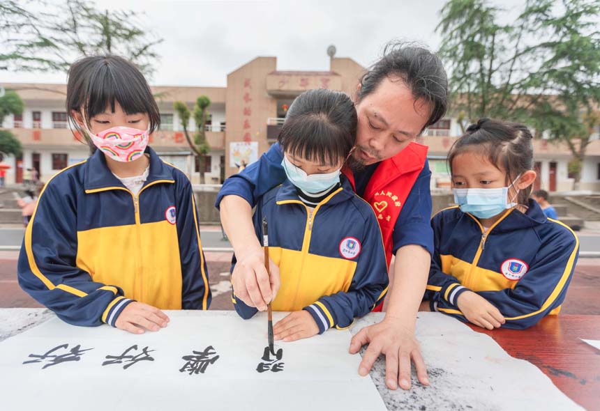 在永新县里田中心小学，胡毅敏在义务教授书法课，为小学生们普及中国书法，弘扬传播书法艺术。（资料图）周亚茂摄