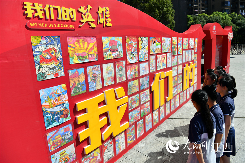 学生们在展板前参观以红色为主题的漫画。 人民网 时雨摄