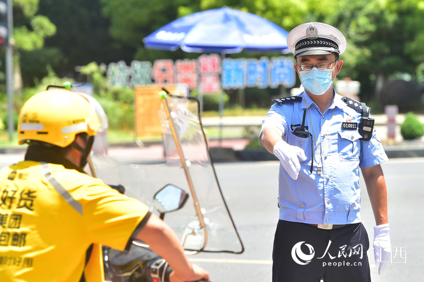 烈日下，交警正在街头指挥交通。 人民网 时雨摄