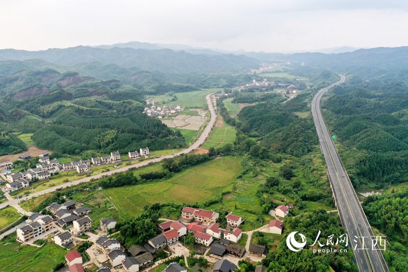 十年来，江西交通运输事业发展成效显著。图为宜黄县境内的抚吉高速从青山中穿越，相邻的农村公路同样铺展开来。 人民网 时雨摄