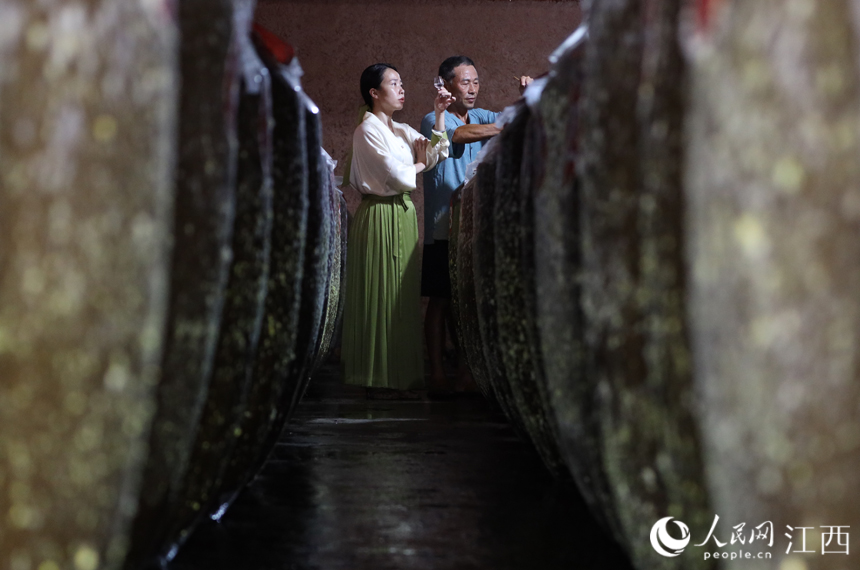 付雅琪与父亲付六如正在酒窖查看酒体陈化情况。丁波 摄