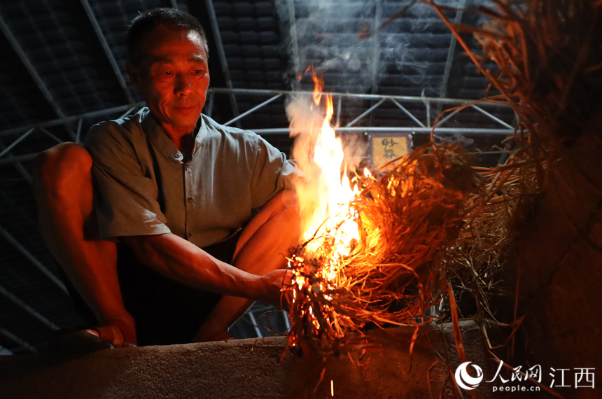 付雅琪的父亲付六如正在点燃稻草准备烧窖消除杂菌。丁波 摄