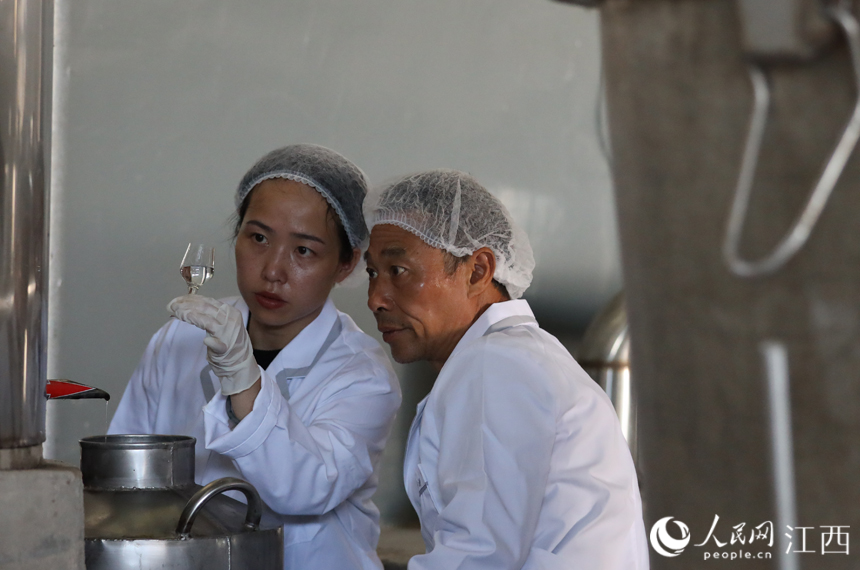 付雅琪与父亲付六如正在查看出酒酒质。丁波 摄