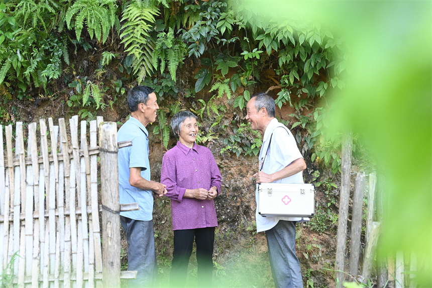 钟文星（右一）向村民宣传健康知识。邓龙华摄