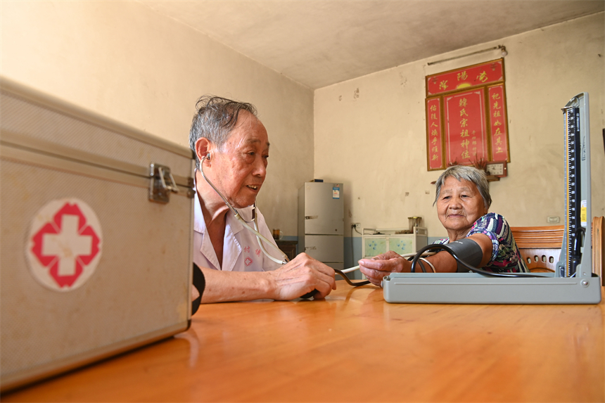 钟文星上户给村民测量血压。邓龙华摄