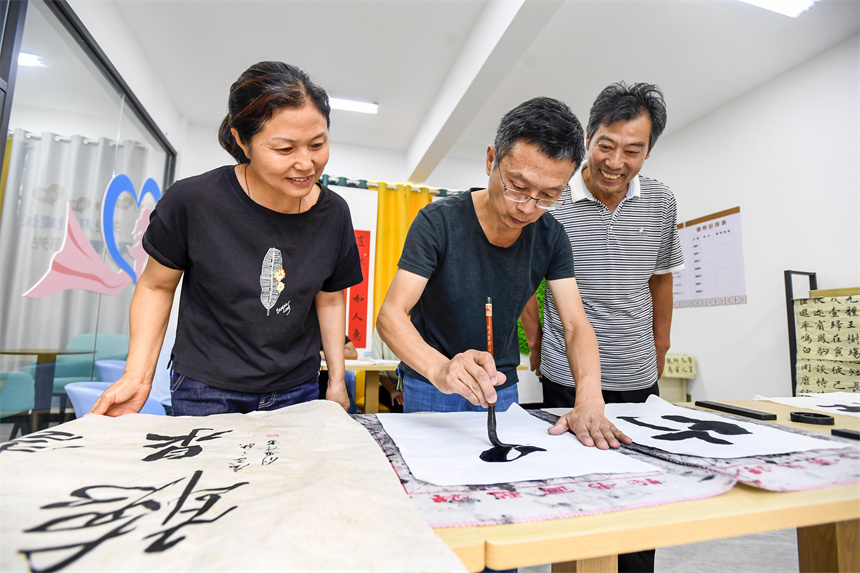 宜豐縣城西社區宜杏小區的居民在鄰裡中心內寫書法、話愛好。周亮攝
