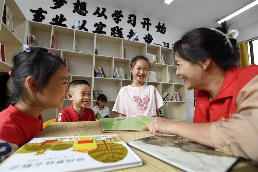 在宜豐縣城西社區宜杏小區鄰裡中心，志願者在和孩子們一起閱讀兒童繪本。周亮攝