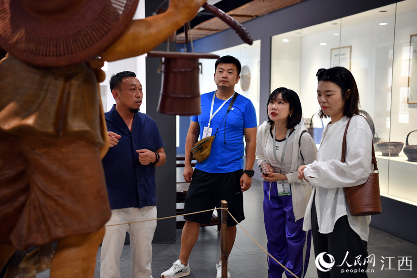 在竹編博物館內，張三石（左）正在向游客介紹收藏的竹編展品。 人民網 時雨攝