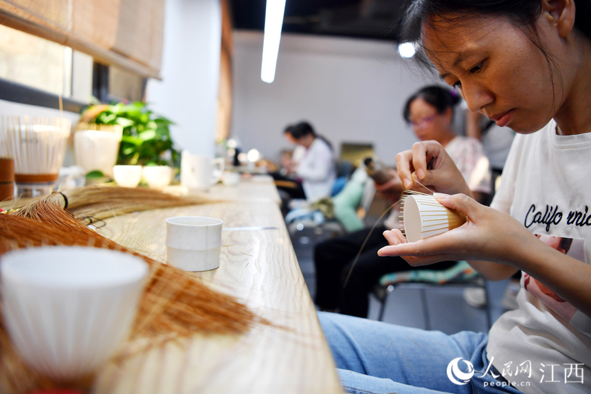 村民们在竹艺中心制作竹编产品，这些精美的产品既美观又实用且销路广。 人民网 时雨摄