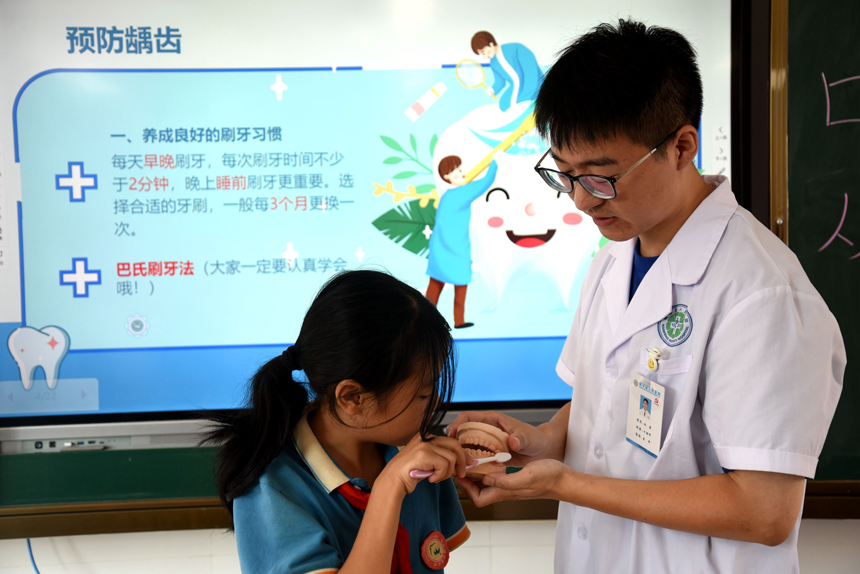口腔科医生指导学生们学习口腔保健知识和正确的刷牙方法。袁荣生 摄